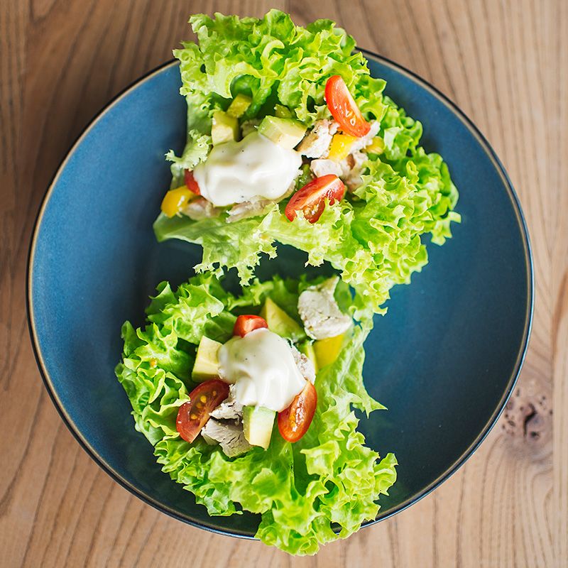 grønne salatblader og andre grønnsaker på grå tallerken